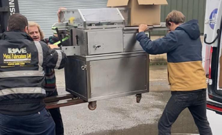 three men lifting a machine